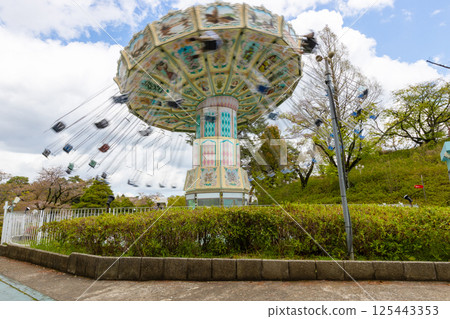 Amusement park attraction [Spinning swing] A playground equipment with a swing that spins around 125443353