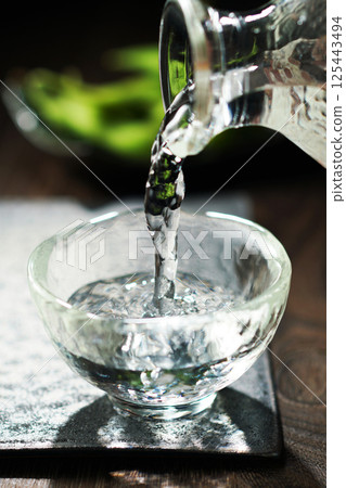 Sake and edamame being poured Sake and edamame being poured 125443494