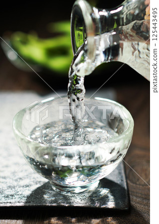 Sake and edamame being poured Sake and edamame being poured 125443495