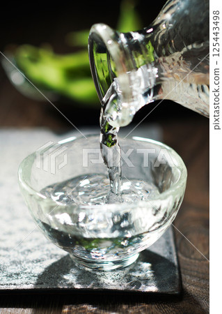 Sake and edamame being poured 125443498