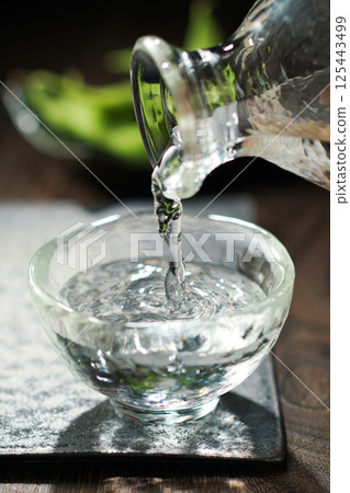 Sake and edamame being poured Sake and edamame being poured 125443499