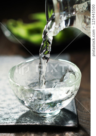 Sake and edamame being poured 125443500