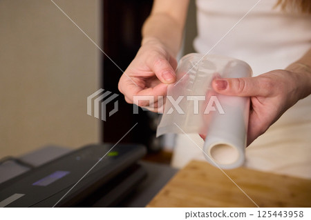 Hands Skillfully Preparing Vacuum Sealing for Food Preservation and Storage Purposes 125443958