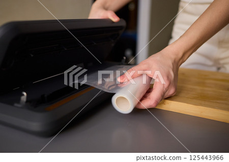 Hands Skillfully Preparing Vacuum Sealing for Food Preservation and Storage Purposes 125443966