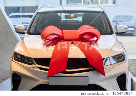 The new car is wrapped in a red bow. Beautiful gift concept. 125443994