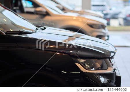 The new car is wrapped in a red bow. Beautiful gift concept. The new car is wrapped in a red bow. Beautiful gift concept. 125444002
