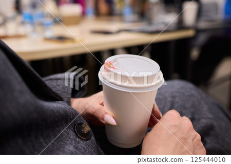 Cozy Moment A Hand Gently Holding a Warm Cup Filled with Delicious and Aromatic Coffee Brew 125444010