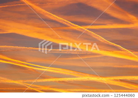 Scenic dramatic colorful sunset or sunrise sky landscape many aircraft jet contrail crossing. Natural beautiful dawn background wallpaper. Twilight time cloudscape. Europe aircraft traffic Scenic dramatic colorful sunset or sunrise sky landscape many aircraft jet contrail crossing. Natural beautiful dawn background wallpaper. Twilight time cloudscape. Europe aircraft traffic 125444060