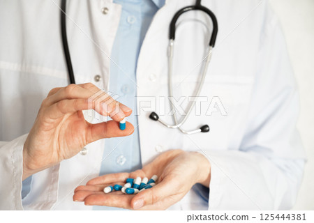 Doctor discusses medication options while seated at a desk in a clinical office setting 125444381