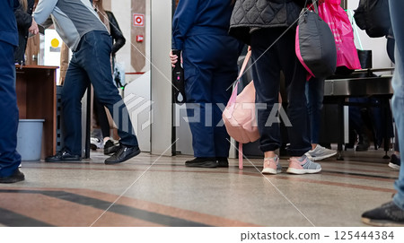 People passing through security checkpoint in a public building during the day People passing through security checkpoint in a public building during the day 125444384