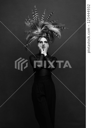 Woman with feather headpiece sensual studio portrait 125444932