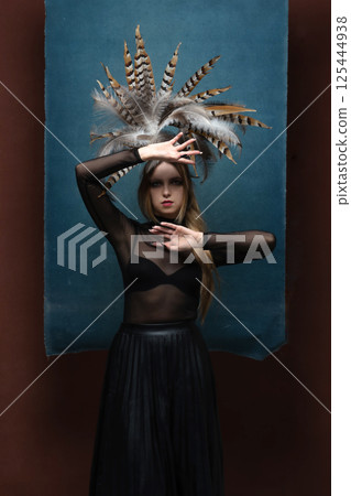 Woman with feather headpiece studio portrait 125444938
