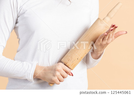 Woman with cooking rolling pin studio portrait 125445061