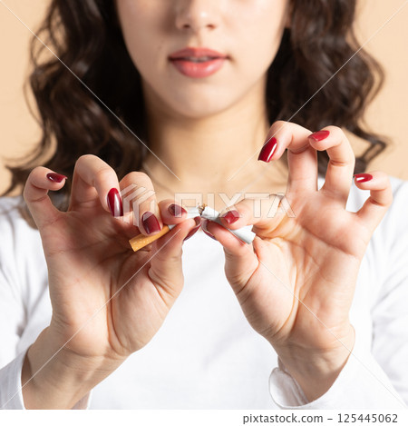 Woman breaking cigarette 125445062