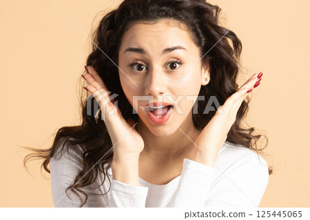 Surprised woman portrait with raised hand palms and open mouth 125445065