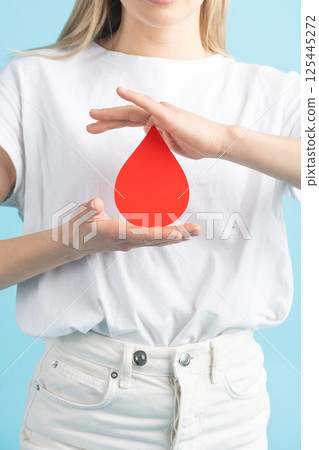 Woman holding red blood drop mockup as symbol of blood donation Woman holding red blood drop mockup as symbol of blood donation 125445272