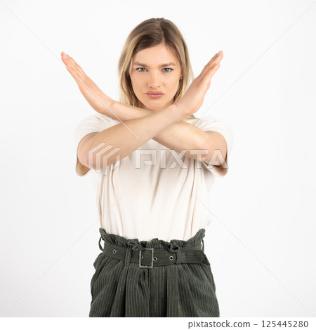 Woman with crossed arms in front of her face studio portrait Woman with crossed arms in front of her face studio portrait 125445280