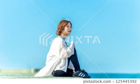 夏天，微笑的女人站在海灘上 125445392