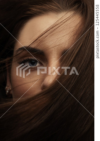 Beautiful woman with blue eyes cover her face with hair Beautiful woman with blue eyes cover her face with hair 125445558