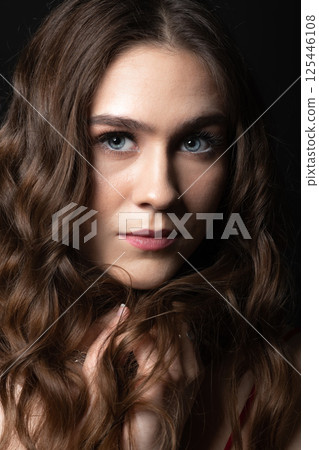 Beautiful brunette woman with long wavy hair studio portrait Beautiful brunette woman with long wavy hair studio portrait 125446108