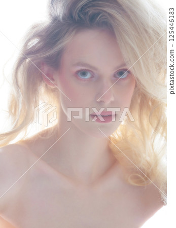Beautiful woman with big wavy hair studio portrait in bright background 125446183