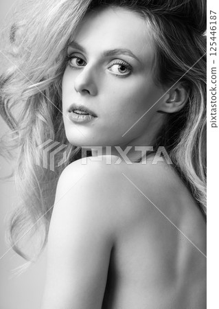 Beautiful blonde woman with big wavy hair and make-up black and white studio portrait 125446187