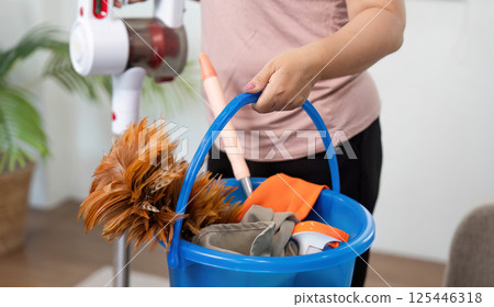 Cleaning Supplies Ready. A woman carries a bucket filled with cleaning tools and supplies. Cleaning Supplies Ready. A woman carries a bucket filled with cleaning tools and supplies. 125446318