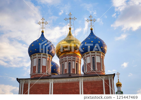 Famous Russian Orthodox Cathedral with golden and blue domes against blue sky with white clouds 125447469