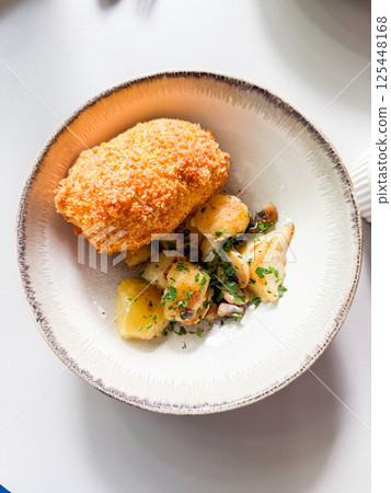 Kiev style chicken cutlet served with mashed potatoes and mushrooms 125448168