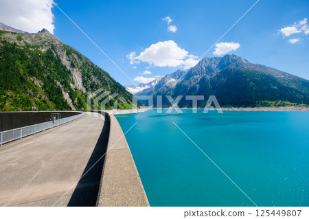 Azure lake, dam and high mountain range in Austria. Mountain landscapes during summer. Azure lake, dam and high mountain range in Austria. Mountain landscapes during summer. 125449807