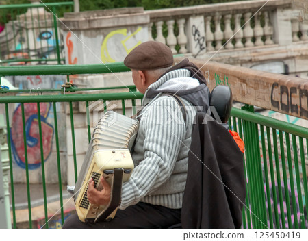Vienna, Austria - 05.13.2023: A street musician plays the button accordion. Vienna, Austria - 05.13.2023: A street musician plays the button accordion. 125450419