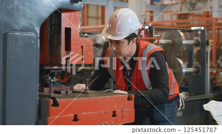 Engineer or operator wearing a safety suit working bending metal sheet by sheet press bending machine in workshop, Worker in factory at metal folding machine putting work piece at factory industry Engineer or operator wearing a safety suit working bending metal sheet by sheet press bending machine in workshop, Worker in factory at metal folding machine putting work piece at factory industry 125451787
