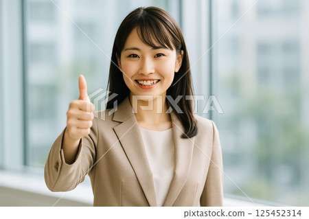 日本年輕女員工在辦公室微笑並豎起大拇指 125452314