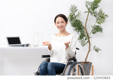 坐在輪椅上在家工作的女人揮舞著雙手 125453603