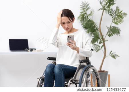 坐在輪椅上在家工作的婦女擔心 125453677
