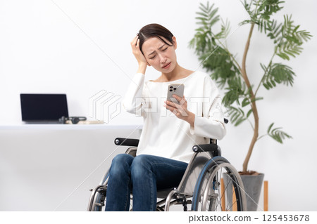 坐在輪椅上在家工作的婦女擔心 125453678