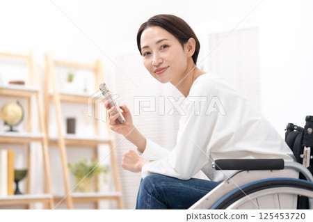 Woman in wheelchair, smartphone Woman in wheelchair, smartphone 125453720