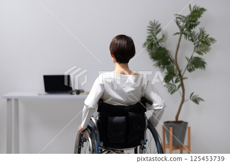Woman in wheelchair, back view Woman in wheelchair, back view 125453739