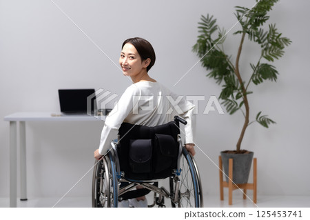 Woman in wheelchair working from home 125453741