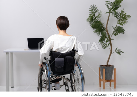 Woman in wheelchair, back view 125453743