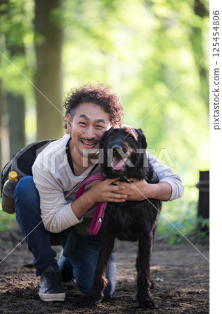 一名男子遛狗，狗訓練師和狗主人友善地看著鏡頭 125454806