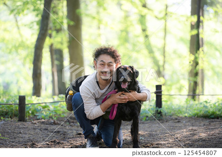 A man walking a dog, a friendly image of a dog trainer and owner, looking at the camera 125454807