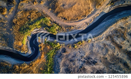Aerial view of a meandering river in a dry landscape. 125455896