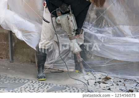 Civil engineering worker breaking concrete with electric hammer (junk hammer) 125456075