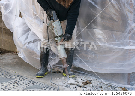 Civil engineering worker breaking concrete with electric hammer (junk hammer) 125456076