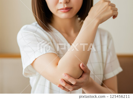 一名婦女感到右手肘疼痛 一名婦女感到右手肘疼痛 125456211