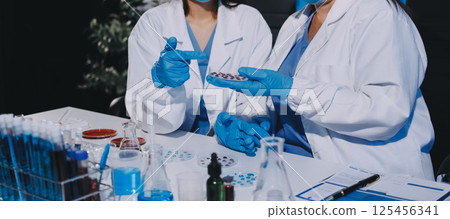 Researcher using a professional microscope Researcher using a professional microscope 125456341