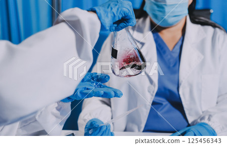 Researcher using a professional microscope Researcher using a professional microscope 125456343