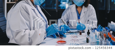 Researcher using a professional microscope Researcher using a professional microscope 125456344
