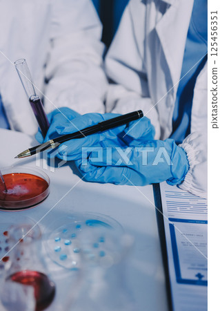 Researcher using a professional microscope Researcher using a professional microscope 125456351